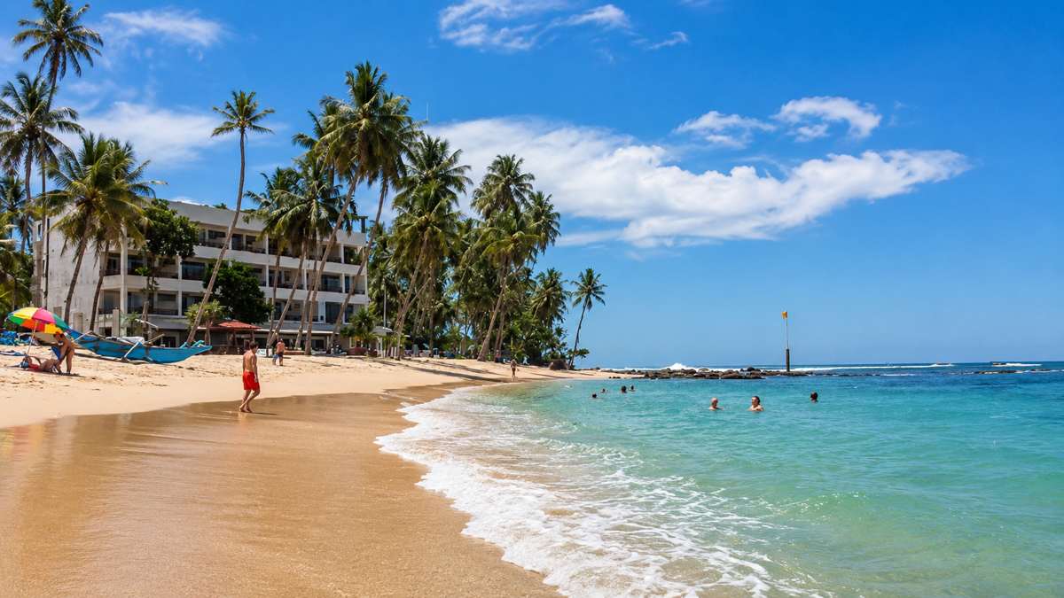 Cool Beach Hotel ඉදිරිපිට රන්වන් වැලි සහ නිල් පැහැති මුහුද
